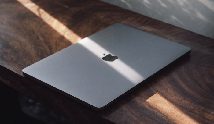 Hình ảnh MacBook Air M2 màu xám trên bàn làm việc, tại vị trí vệt nắng đi qua màu sáng hơn và có “lấp lánh” hơn