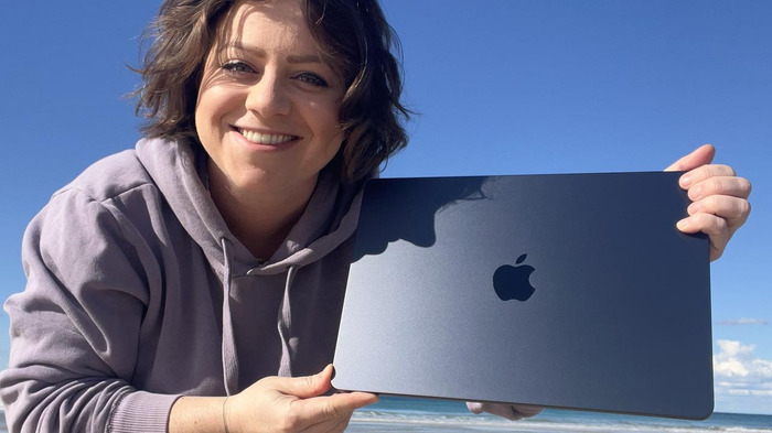 MacBook Air M2 trên tay người dùng nhưng ở bên ngoài trời nắng nhìn rất bắt mắt và thu hút